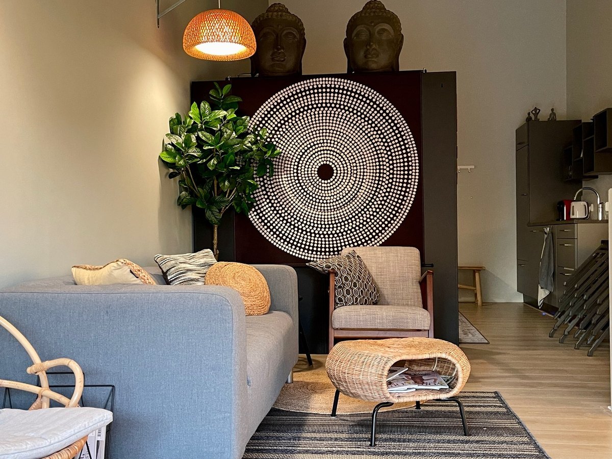 De ontvangstruimte met bank, planten en kast