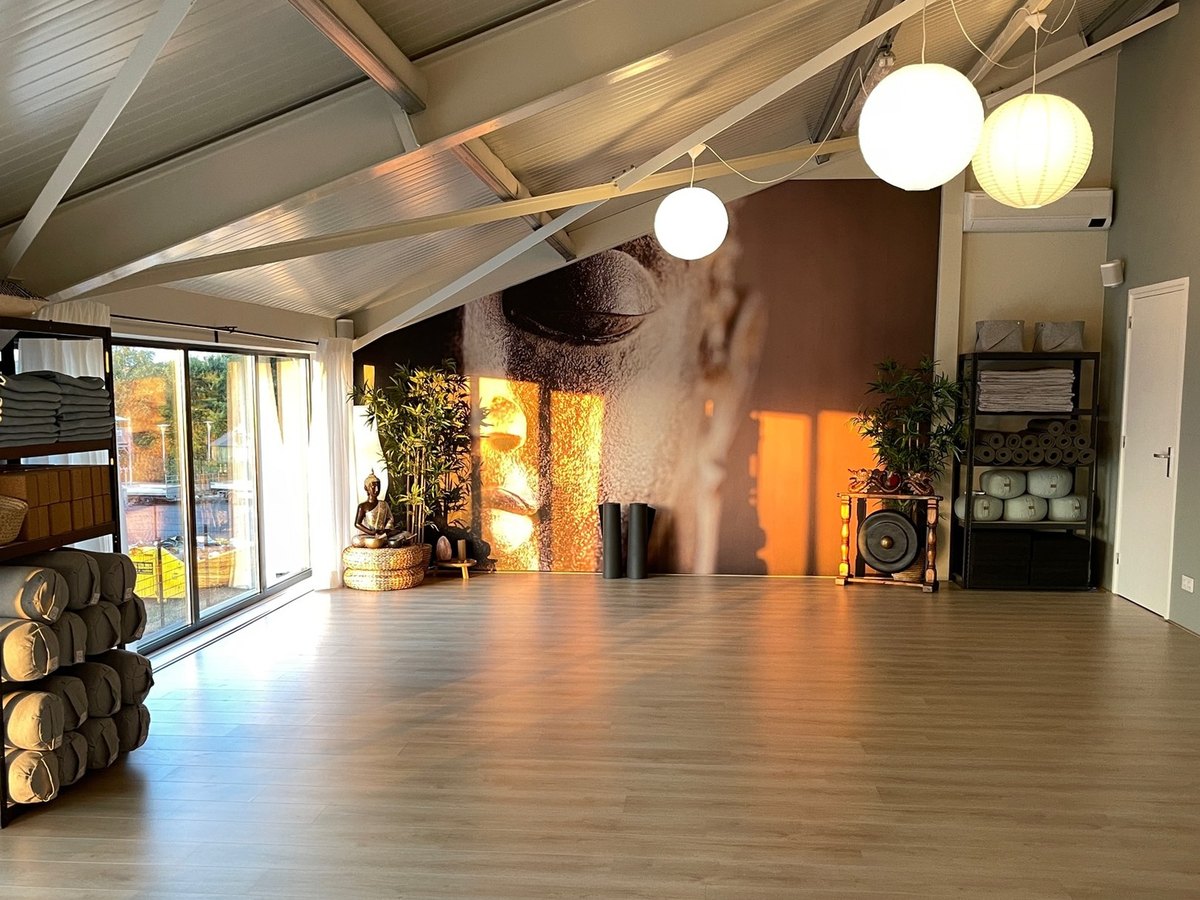 De yogazaal: houten vloer, matten langs de wand, licht door de ramen